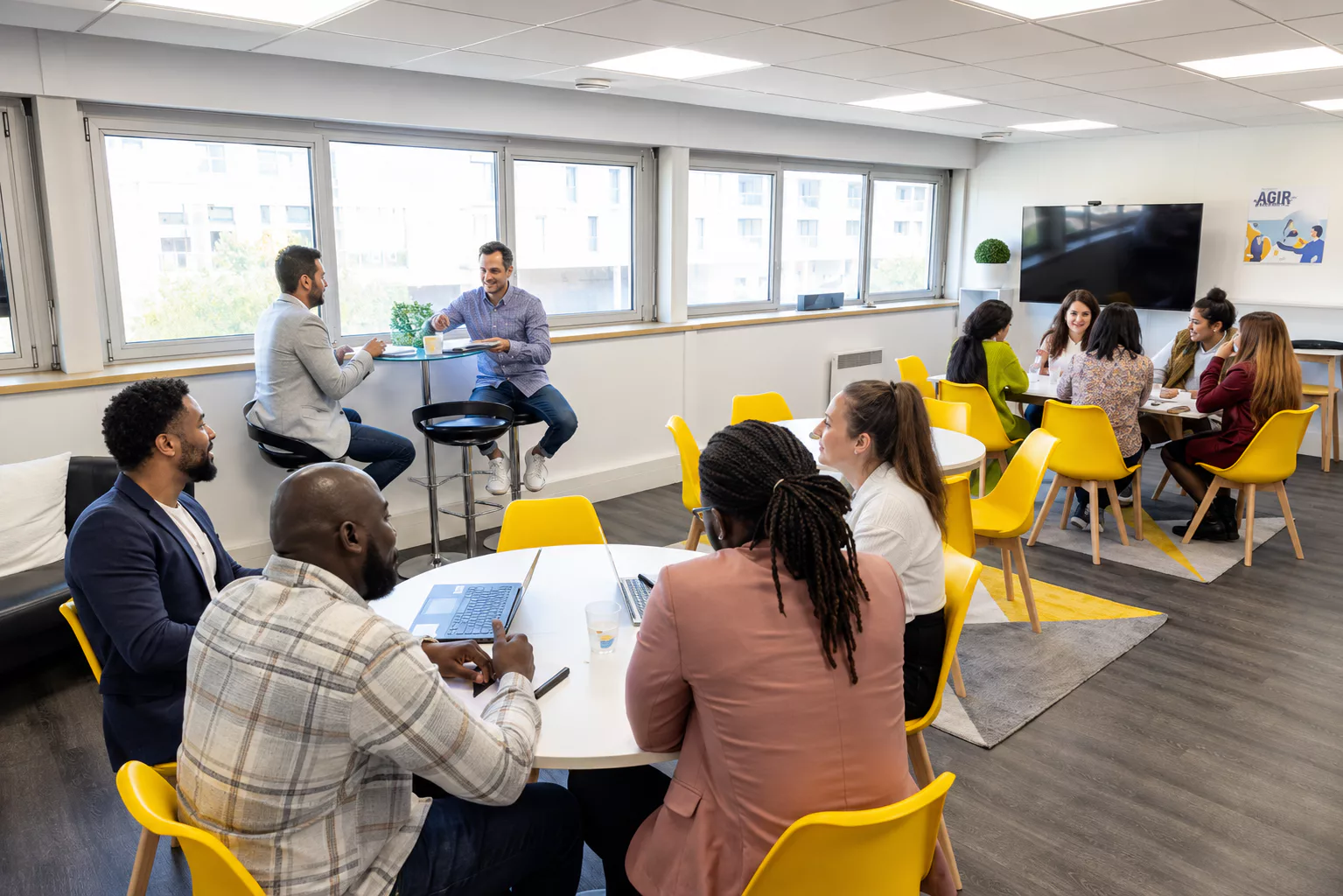 Équipe réunie en ateliers collaboratifs dans un espace de travail lumineux